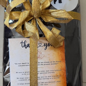 May include: A wrapped gift with a gold ribbon and bow. A small card with the words "thank you" and a logo is attached. The gift is from Lanka Megamart.