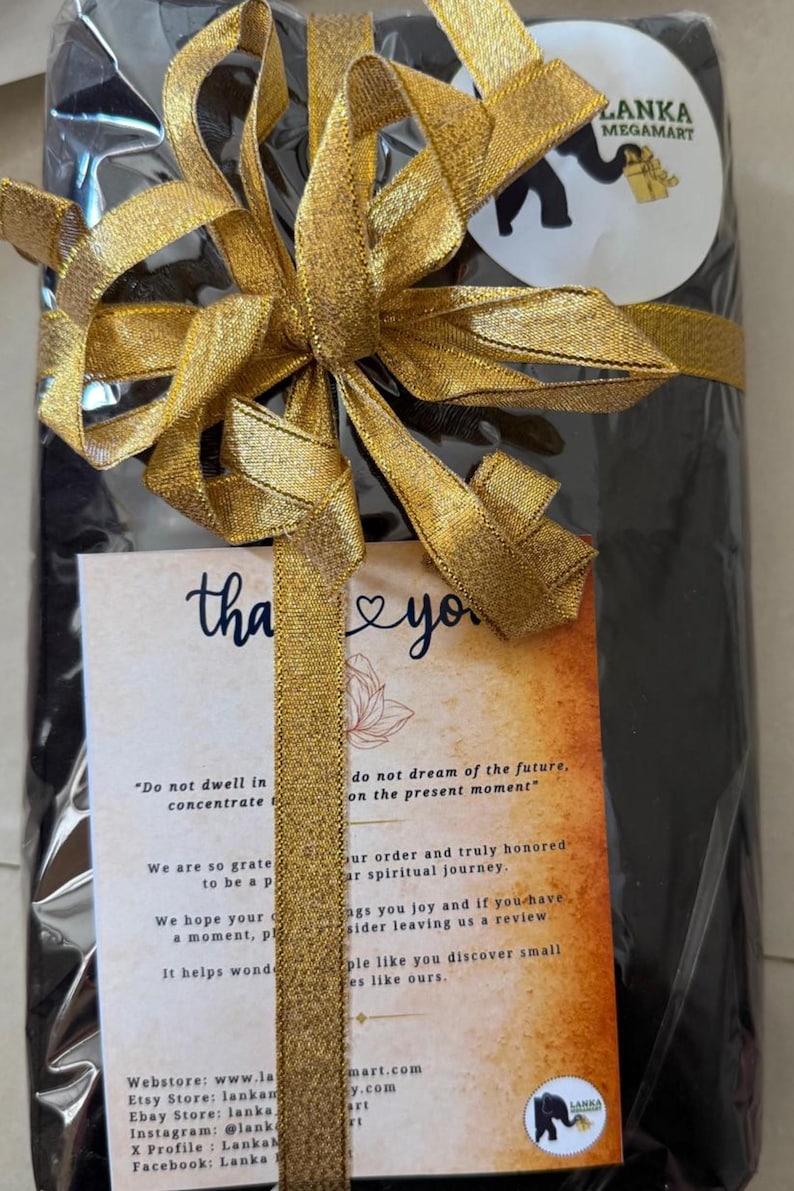 May include: A wrapped gift with a gold ribbon and bow. A small card with the words "thank you" and a logo is attached. The gift is from Lanka Megamart.