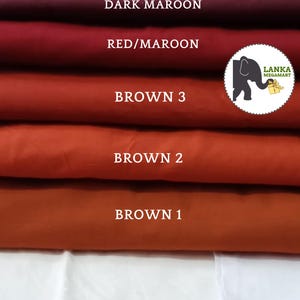 Peut inclure: Six échantillons de tissu dans différentes nuances de brun, rouge et marron. Les échantillons sont étiquetés avec leurs noms de couleur : Mustard Brown, Dark Maroon, Red/Maroon, Brown 3, Brown 2 et Brown 1. Un t-shirt blanc est visible en bas de l'image.