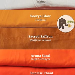 May include: A stack of fabric samples in various colors, including black-toned maroon, white, yellow, saffron yellow, light orange, and two shades of orange. The text on the image identifies each color. A logo with an elephant is visible.