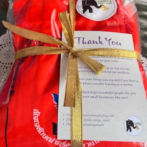 May include: A red fabric package tied with a gold ribbon and a thank you note. The note says "Thank You" and includes the text "at means the world to us and we're grateful for your order." The note also includes the text "lankammart.etsy.com, lanka_mega_mart, nkamegamart".