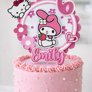 May include: A pink birthday cake with a decorative topper featuring Hello Kitty and My Melody characters. The topper includes the number 6 and the name "Emily". The cake is decorated with pink frosting and white sprinkles.
