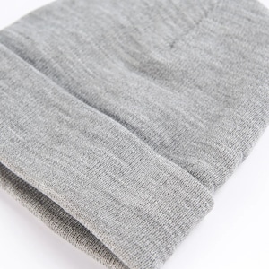 Puede incluir: Primer plano de un gorro gris. El gorro est&aacute; hecho de un material suave y tejido y tiene un borde doblado. El gorro es de color liso y neutro, adecuado para varios atuendos y estilos. El gorro tiene un dise&ntilde;o simple y cl&aacute;sico.