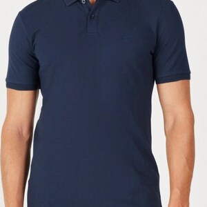 May include: A navy blue polo shirt with short sleeves and a collared neckline. The shirt has a three-button placket and a small logo on the chest. The fabric appears to be a soft, knit material.