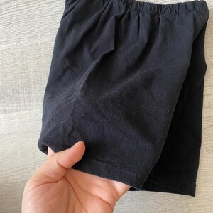 May include: Black cotton shorts with a wide elastic waistband.