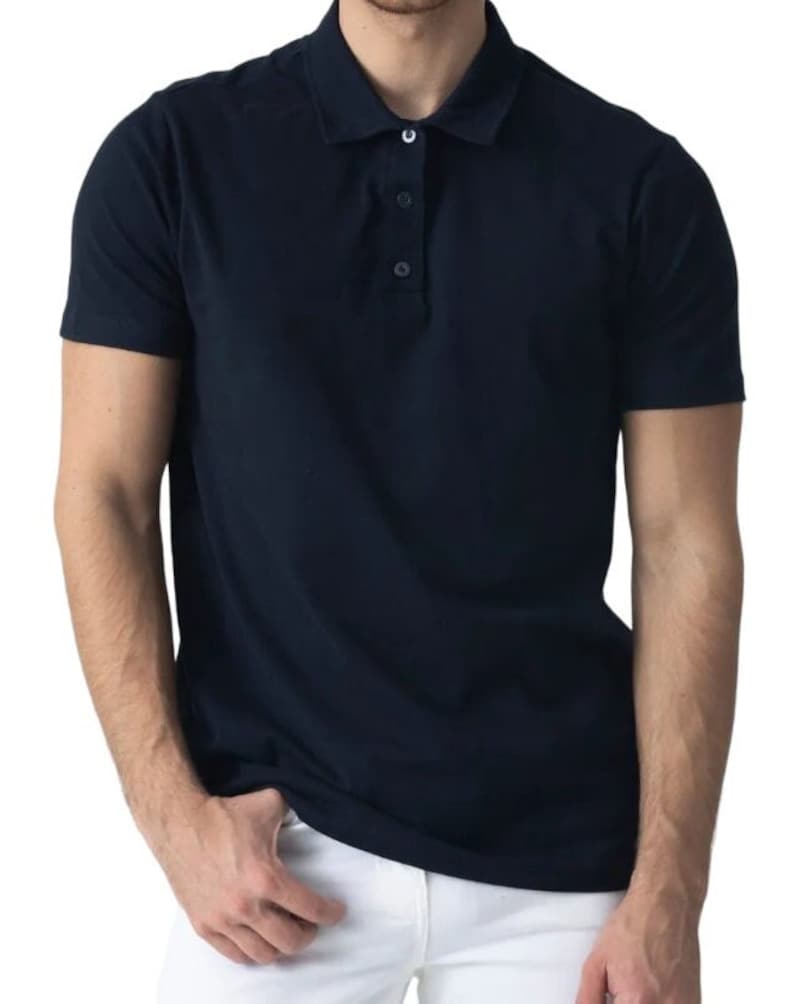 May include: A navy blue polo shirt with short sleeves and a three-button placket. The shirt has a classic collar and is made of a smooth, solid-colored fabric. The shirt is shown on a person.