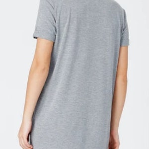 May include: A gray short-sleeved t-shirt dress with a relaxed fit.