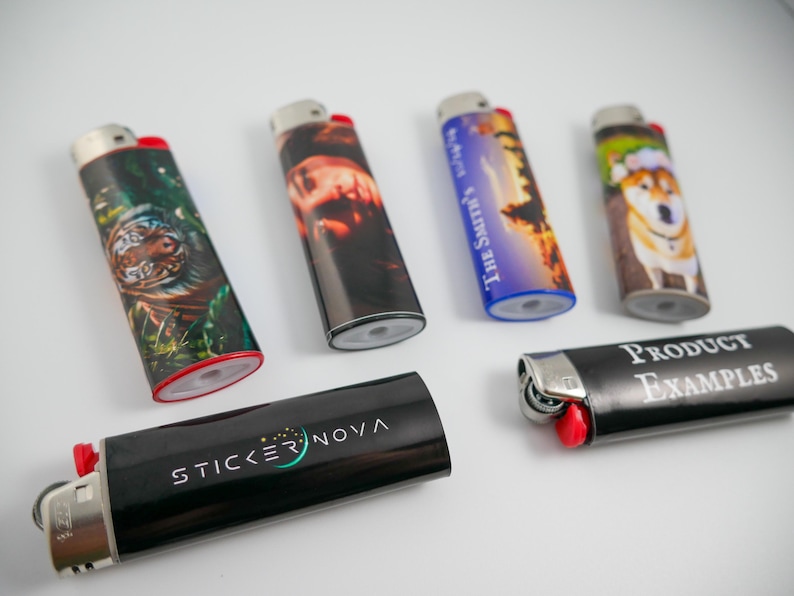 Pu&ograve; includere: Sei accendini rettangolari con vari disegni stampati. Uno raffigura una tigre, uno un ritratto, uno un tramonto con il testo THE SMITH'S, uno un cane, uno il testo STICKER NOVA e uno il testo PRODUCT EXAMPLES. Ognuno ha una parte superiore in metallo.