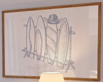May include: A framed illustration of four surfboards leaning against a wooden rack with a cowboy hat on top. The illustration is in shades of blue and white on a white background. The frame is light brown wood.