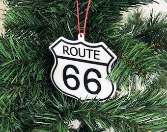 Op de afbeelding: Witte Route 66-teken ornament hangend aan een groene kunstkerstboom.