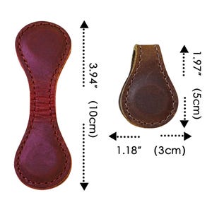 Pu&ograve; includere: Due clip magnetiche in pelle. Una &egrave; di colore bordeaux scuro, lunga 10 cm, e l'altra &egrave; marrone, lunga 5 cm. Entrambe hanno un bordo cucito e sono larghe 3 cm.