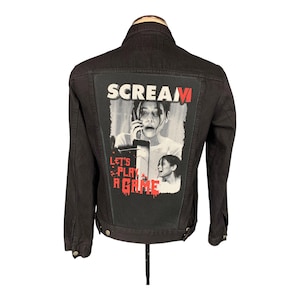May include: Dark denim jacket with a graphic on the back. The graphic features a distressed image from the film "Scream", with the word "SCREAM" in white and red, and the phrase "LET'S PLAY A GAME".
