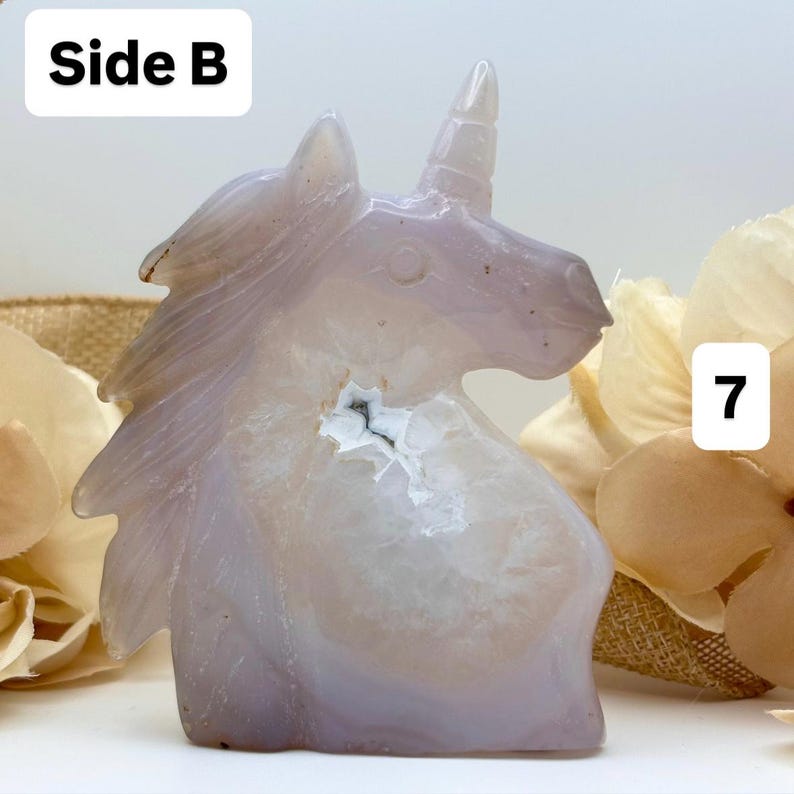 May include: A carved, light purple unicorn figurine. The crystal sculpture has a white and gray interior with a small cavity. The text "Side B" is in the upper left corner, and the number "7" is in the upper right corner.
