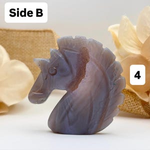 May include: A carved stone sculpture of a horse's head. The sculpture is primarily blue-grey with brown and white veining. The word "Side B" is in a white box in the upper left corner, and the number "4" is in a white box in the lower right corner.