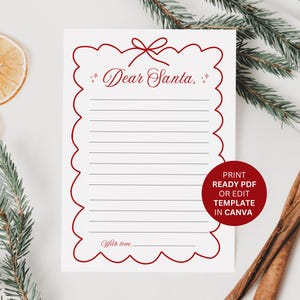May include: A white letter to Santa Claus with a red scalloped border and the words "Dear Santa," at the top. The letter has lined spaces for writing and a red circle with text. Cinnamon sticks, dried orange slices, and pine branches are in the background.