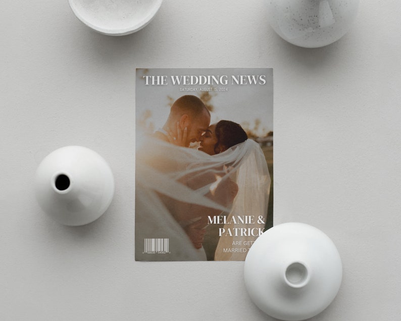 May include: A magazine cover titled "THE WEDDING NEWS" featuring a couple embracing. The cover includes the date "SATURDAY, AUGUST 15, 2024" and the names "MELANIE & PATRICK". White vases surround the magazine on a gray surface.