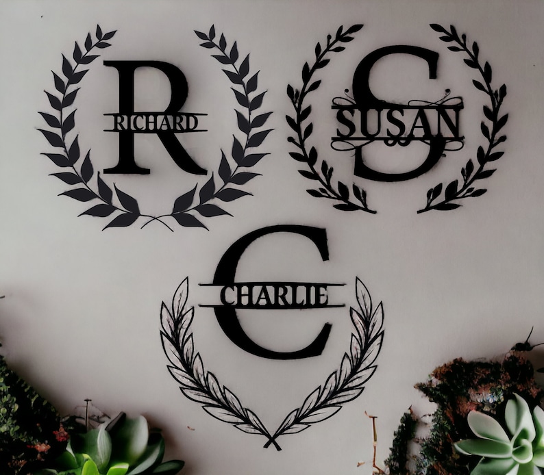 K&ouml;nnte beinhalten: Drei schwarze Wanddekorationen aus Metall mit einem Kranzdesign und einem Buchstaben in der Mitte. Die Buchstaben sind "R", "S" und "C". Die Namen "Richard", "Susan" und "Charlie" sind auf den Kr&auml;nzen geschrieben.