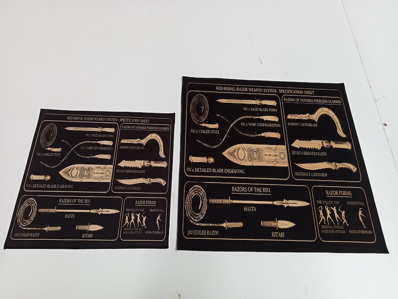 May include: Two black rectangular prints featuring gold line art diagrams titled Red Rising: Razor Weapon System - Specification Sheet. The graphics display various blade forms, coiled states, detailed engravings, and weapon forms with labels.