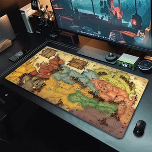 May include: A rectangular desk mat featuring a detailed fantasy map illustration with varied terrain in shades of yellow, green, red, and blue. The map includes grid coordinates along the edges, mountain ranges, forest icons, and two parchment-style text boxes.