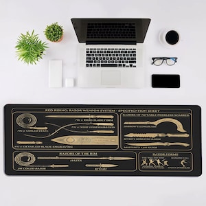 May include: A black rectangular desk mat featuring a gold-colored technical diagram titled Red Rising: Razor Weapon System. The print displays various blade forms, whip configurations, and weapon specifications with detailed labels and line art illustrations.