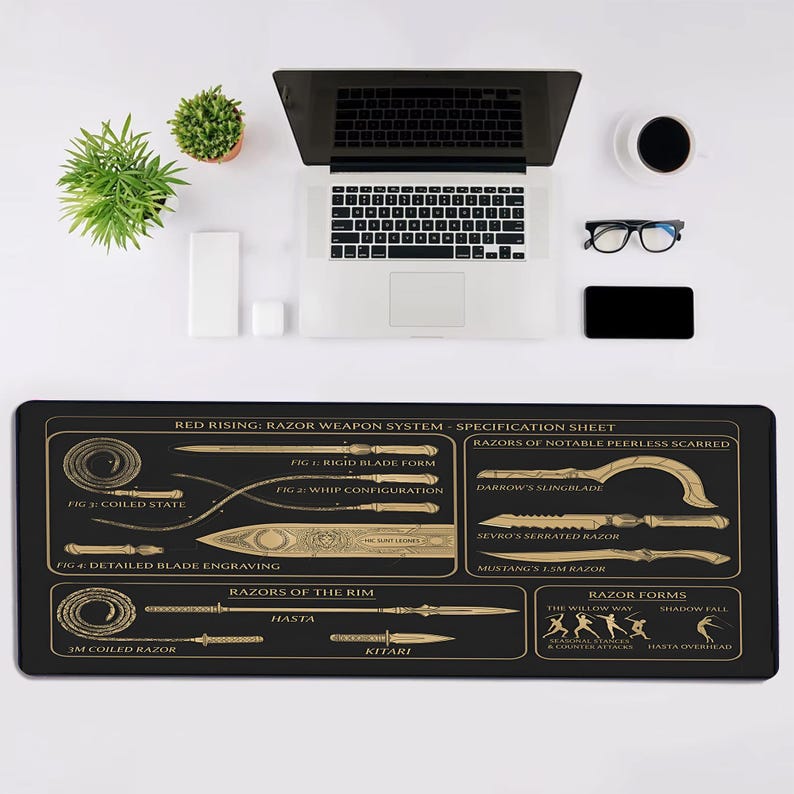 May include: A black rectangular desk mat featuring a gold-colored technical diagram titled Red Rising: Razor Weapon System. The print displays various blade forms, whip configurations, and weapon specifications with detailed labels and line art illustrations.