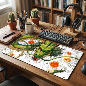 May include: A rectangular desk mat featuring a detailed illustration of a green dragon with red eyes and long whiskers, surrounded by several orange spheres with red stars, set against a white background with faint technical line drawings.