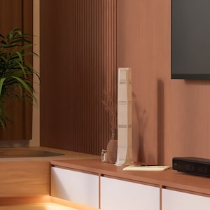 May include: A modern living room with a wooden wall, a television, and a white decorative object on a wooden shelf. The shelf has white drawers and a brown countertop.