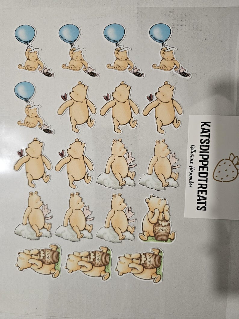 May include: A sheet of Winnie the Pooh stickers. The stickers feature Pooh Bear in various poses, including holding a blue balloon, sitting on a cloud, and with a honey pot. The stickers are tan, with accents of blue, pink, and brown.