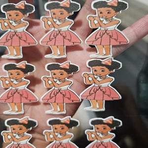May include: A collection of stickers featuring a cartoon girl in a pink dress and a party hat. The stickers have a white top, a pink skirt, and white shoes. The girl is smiling and has dark hair.