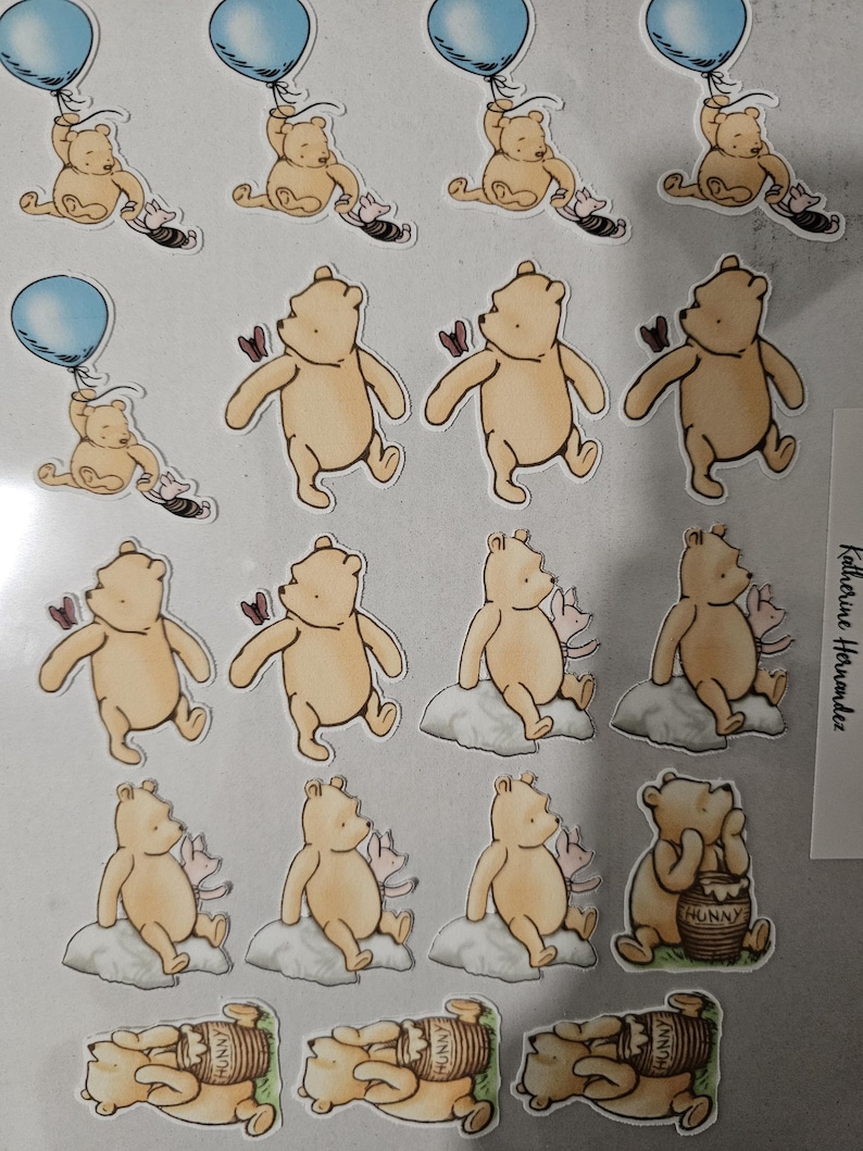May include: A collection of Winnie the Pooh-themed stickers. The stickers feature Pooh Bear in various poses, including holding a blue balloon, with a butterfly, sitting on a cloud, and with a honey pot. The stickers are in a cartoon style.
