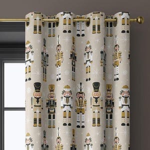 May include: Beige curtain with a repeating pattern of nutcracker soldiers in black, gold, and white. The curtain is hanging on a gold rod. The design includes snowflakes, creating a festive holiday theme.