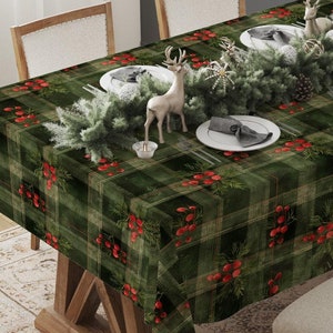 May include: A green plaid tablecloth with red berry accents covers a wooden table set for a holiday meal. The table is decorated with a garland, plates, napkins, and decorative deer figurines. The room has a neutral color scheme.
