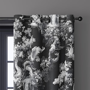 May include: Black and white patterned curtain featuring a detailed landscape design with trees, birds, and waterfalls. The curtain has grommets for hanging and is mounted on a black rod. The overall theme is nature and home decor.