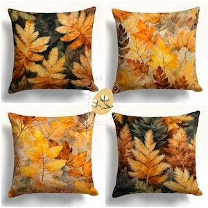 May include: Four square throw pillows with a watercolor pattern of autumn leaves in shades of yellow, orange, brown, and green.