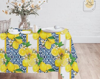 May include: White tablecloth with a lemon and blue tile pattern. The tablecloth has yellow stripes and is set on a wooden table.