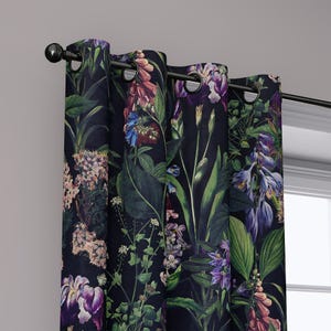May include: Dark navy blue floral curtains with a botanical print featuring purple, pink, and blue flowers, and green leaves. The curtains are hung on a black rod with black grommets. The design is a detailed, artistic rendering of various flowers and foliage.