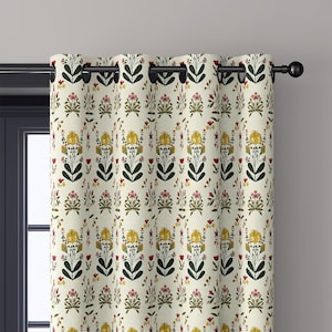 May include: A cream-colored curtain panel featuring a repeating botanical pattern of yellow, red, and dark green flowers and leaves. The curtain is suspended from a black metal rod by evenly spaced circular grommets along the top edge.