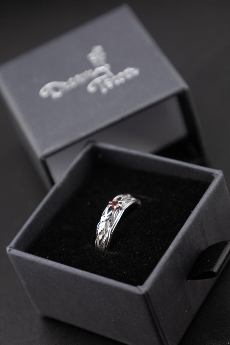 Sterling silver Norse raven ring resting in an open black velvet-lined Dream Tower jewelry box, viewed from above on a dark surface