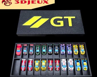 Könnte beinhalten: Eine Sammlung von Miniatur-Spielzeugautos in einer schwarzen Vitrine. Die Autos sind bunt mit verschiedenen Designs. Die Vitrine hat einen schwarzen Deckel mit den gelben Buchstaben "GT". Das Logo "3D JEUX" befindet sich oben links.