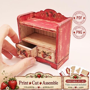May include: A miniature red and cream wooden-style cabinet with a pull-out drawer, featuring strawberry illustrations and a distressed finish. The set includes printable PDF and PNG files for assembly, labelled Print Cut Assemble.