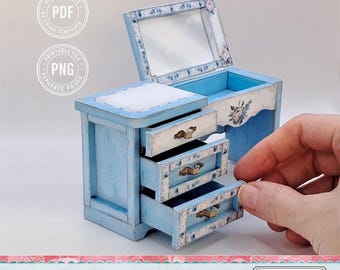 May include: A miniature blue dresser with three drawers, a mirror, and floral accents. The text "Print Cut Assemble" is visible. The dresser is part of a printable DIY set.