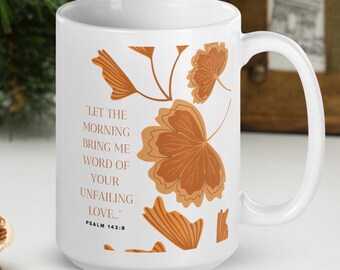 May include: White ceramic mug with a large handle, featuring brown leaf illustrations and the text "LET THE MORNING BRING ME WORD OF YOUR UNFAILING LOVE..." from Psalm 143:8. The mug has a glossy finish and is suitable for hot or cold beverages.