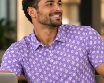 May include: A short-sleeved polo shirt in a light purple hue, featuring a repeating pattern of white squares with soft, rounded corners. The garment includes a classic collar and a buttoned placket down the center front.