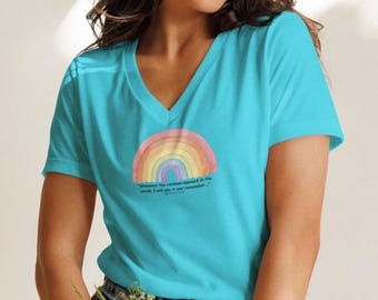 May include: A turquoise V-neck t-shirt featuring a watercolor rainbow design. The rainbow is in shades of red, orange, yellow, and blue. The shirt has the quote, "Whenever the rainbow appears in the clouds, I will see it and remember..."