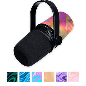 May include: A black microphone with a black handle and a black foam windscreen. The microphone has a colorful, swirling pattern on the body, featuring shades of pink, orange, and yellow. The microphone is designed for recording.