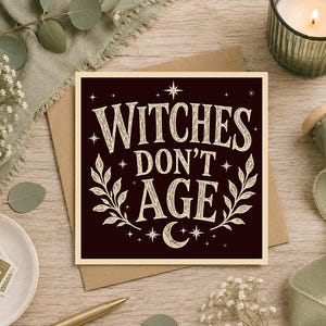 May include: A square greeting card with a dark brown background and cream-coloured text that reads WITCHES DON'T AGE. The design features decorative leafy branches on the sides, a crescent moon at the bottom, and small star accents throughout.