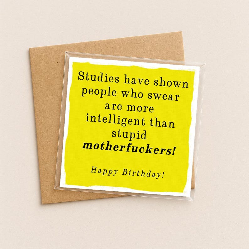 May include: A square greeting card with a bright yellow front featuring black text that reads: Studies have shown people who swear are more intelligent than stupid motherfuckers! Happy Birthday! The card is placed against a brown envelope.