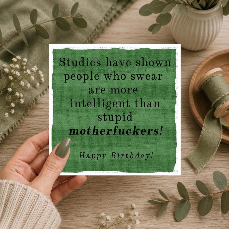 May include: A square greeting card with a textured green background and black text that reads: Studies have shown people who swear are more intelligent than stupid motherfuckers! Happy Birthday! The card has a white border.
