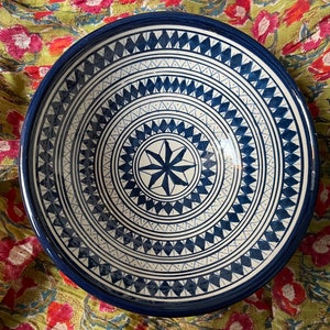 Może przedstawiać: Duża, biała ceramiczna miska z niebieskim rantem i skomplikowanymi geometrycznymi wzorami w kolorze niebieskim. Miska ma gwiaździsty wzór w środku.