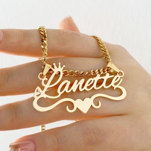 May include: Gold necklace with a cursive name pendant that says "Lanette" with a crown above the first letter and a heart below the name.
